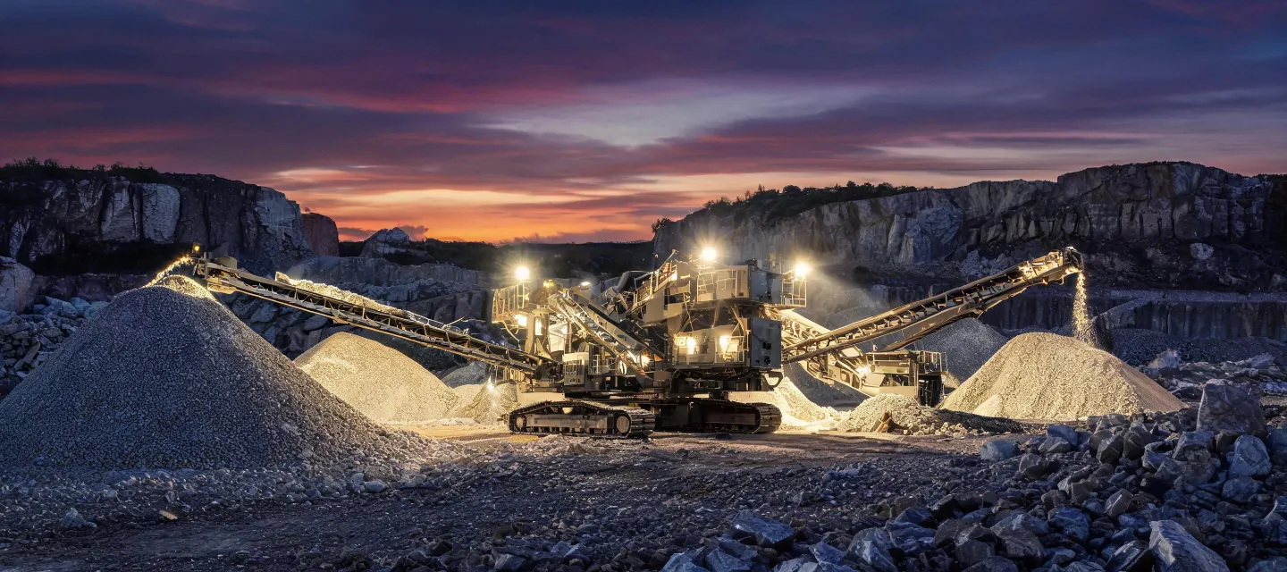Mobile crushing plant working at dusk in quarry